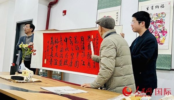 旅秘書法家向現(xiàn)場(chǎng)觀眾展示書法作品。人民網(wǎng)記者 宋亦然攝