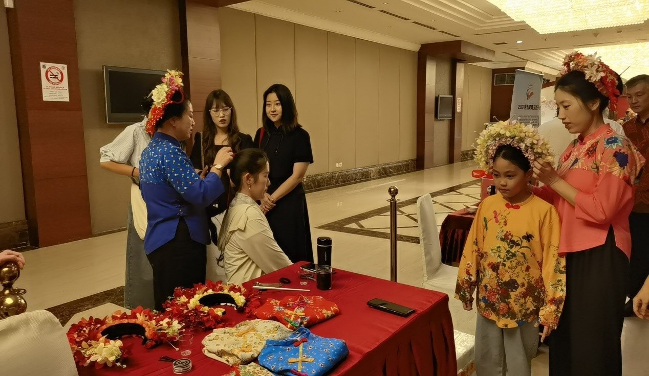 阿拉扎大學(xué)孔子學(xué)院志愿者老師向傳承人學(xué)習(xí)簪花圍。阿拉扎大學(xué)孔子學(xué)院供圖