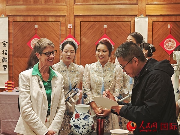 現(xiàn)場(chǎng)的非遺傳承人為英國(guó)觀眾展示畫技。人民網(wǎng)記者 邢雪攝