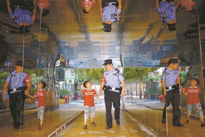 ?7月16日，重慶市公安局江北區(qū)分局一名民警在巡邏途中遇到一個(gè)獨(dú)自玩耍的小男孩，民警將其送回家。王洪平攝