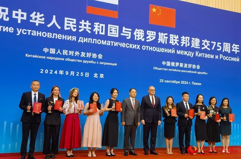 楊萬(wàn)明會(huì)長(zhǎng)和莫爾古洛夫大使為10位中俄青年友好微視頻創(chuàng)意大賽獲獎(jiǎng)代表頒獎(jiǎng)。人民網(wǎng)記者 李明琪攝