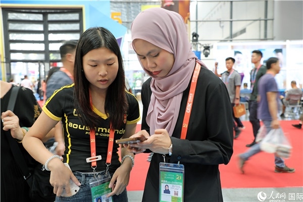 東博會現(xiàn)場，馬來西亞展商在同中方工作人員交談。人民網(wǎng)記者 趙益普攝