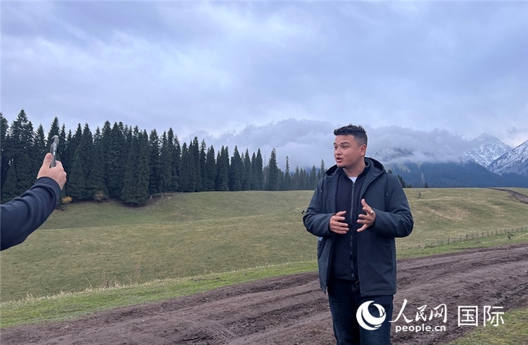 在庫爾德寧，吾買爾江被雪山美景震撼，即興錄制了短視頻作品。人民網(wǎng)記者曾書柔攝