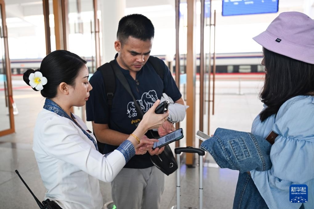 10月12日，在老撾萬象中老鐵路萬象站，工作人員檢驗乘客車票。新華社記者 程一恒 攝