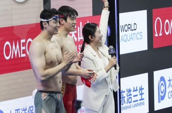  10月18日，汪順（左）和潘展樂在男子100米混合泳決賽后。新華社記者 方喆 攝