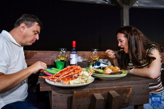 9月2日，食客們在俄羅斯符拉迪沃斯托克的一家餐館品嘗帝王蟹。新華社記者 曹陽 攝