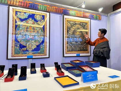 熱貢藝術(shù)國(guó)家級(jí)代表性傳承人夏吾角向嘉賓介紹作品。人民網(wǎng)記者 簡(jiǎn)承淵攝