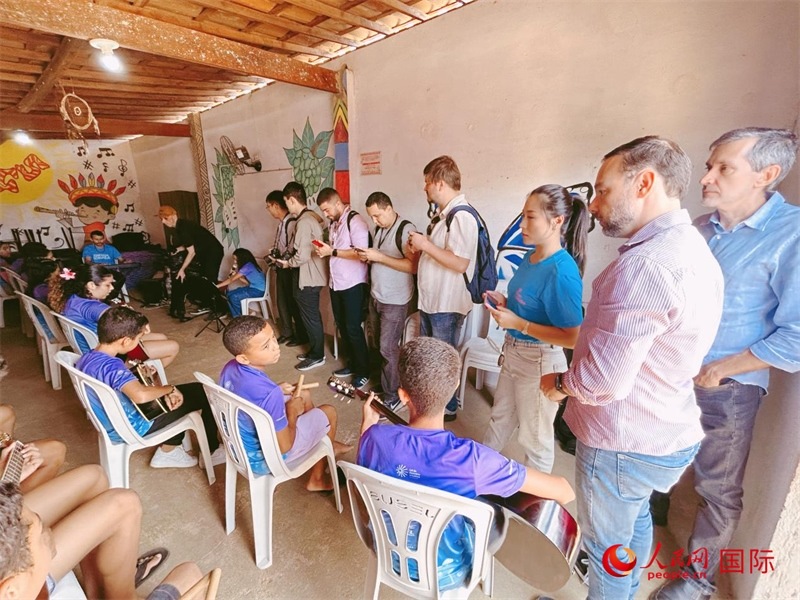  受益于中國企業(yè)的“青少年成長”項目，700多名當?shù)厍嗌倌甑囊魳泛妥闱驂粝氩迳狭顺岚?。圖為聯(lián)合采訪團正在采訪參加音樂培訓的孩子們。 人民網(wǎng)記者 陳一鳴攝