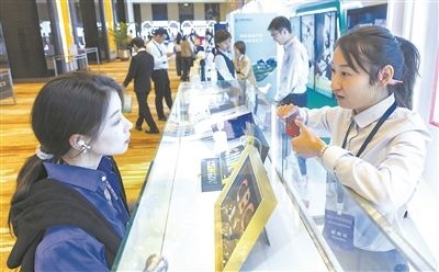 在北京麗澤商務(wù)區(qū)，工作人員（右一）介紹數(shù)字人民幣SIM卡硬錢包。新京報記者 陶冉攝