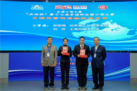中央廣播電視總臺國際視頻通訊社定稿專家邱鵬鳴（右一）、人民網(wǎng)日文版主任編輯許永新（左一）為獲得日語交傳組二等獎的北京第二外國語學(xué)院張宏瑞、上海外國語大學(xué)劉蕊頒獎。主辦方提供）