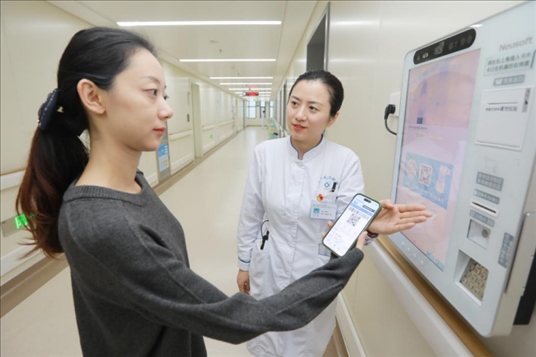 醫(yī)護(hù)人員引導(dǎo)患者在自助機(jī)前辦理自助入院手續(xù)。圖片來(lái)源：山東第一醫(yī)科大學(xué)第二附屬醫(yī)院