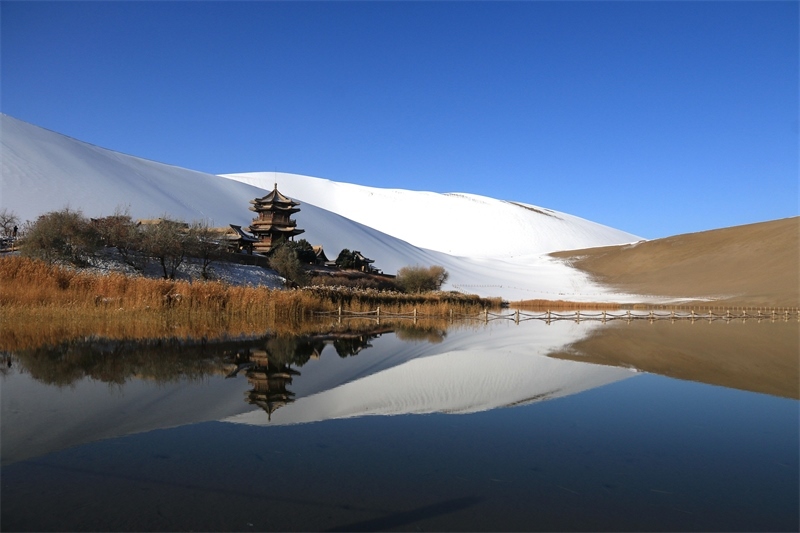 鳴沙山月牙泉景區(qū)雪景。敦煌市委宣傳部供圖，張曉亮攝