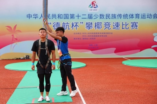 11月23日，工作人員為上海隊(duì)選手付樂(lè)樂(lè)（左）系安全繩。新華社記者 楊植森 攝