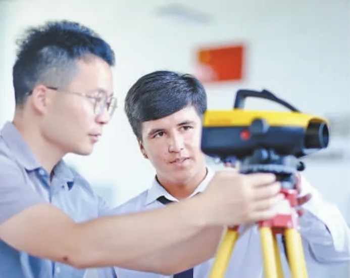 在塔吉克斯坦首都杜尚別的魯班工坊，來自天津城市建設(shè)管理職業(yè)技術(shù)學院的老師（左）為當?shù)貙W生提供指導。新華社記者 鄭開君 攝