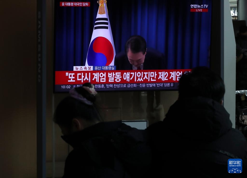 12月7日，在韓國(guó)首爾火車站，民眾觀看總統(tǒng)尹錫悅發(fā)表講話的電視畫面。新華社記者 姚琪琳 攝