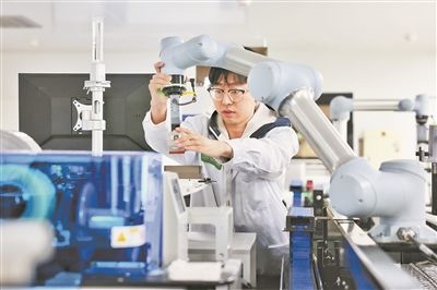 廣東省深圳市科研人員在實(shí)驗(yàn)室調(diào)試智能機(jī)器人。視覺中國供圖