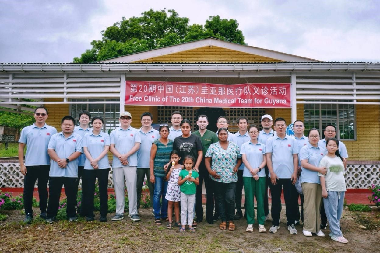 第20期中國(guó)（江蘇）援圭亞那醫(yī)療隊(duì)在圭偏遠(yuǎn)的林登高速社區(qū)開展義診后，與部分當(dāng)?shù)鼐用窈嫌啊?中國(guó)援圭醫(yī)療隊(duì)供圖
