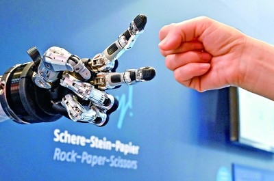 在德國(guó)漢諾威工博會(huì)上，參觀者與一款智能機(jī)器人進(jìn)行“石頭剪子布”游戲。新華社發(fā)