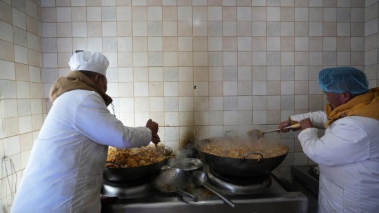 1月14日，服務(wù)隊的兩名廚師正在為村民們做午飯。新華社記者 邱星翔 攝