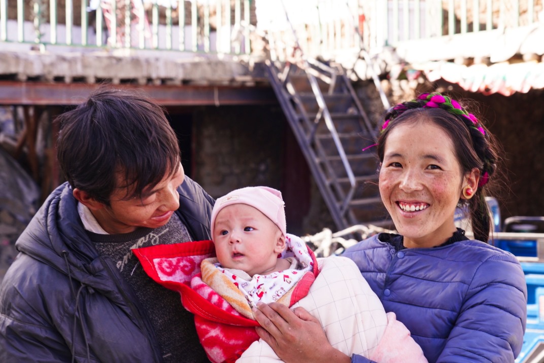 1月11日，在西藏日喀則市人民醫(yī)院，受災(zāi)群眾抱著自己在地震中受傷的孩子康復(fù)出院。人民日報記者徐馭堯攝