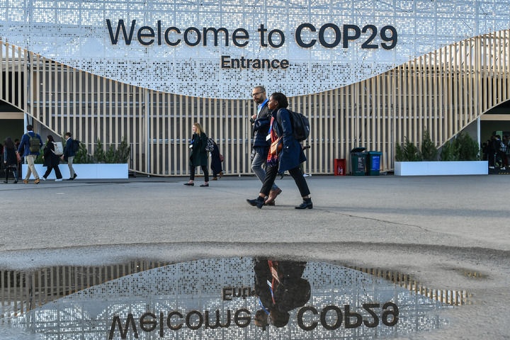 2024年11月15日，在阿塞拜疆首都巴庫(kù)，人們經(jīng)過(guò)聯(lián)合國(guó)氣候變化巴庫(kù)大會(huì)的會(huì)場(chǎng)。新華社記者 曹陽(yáng) 攝