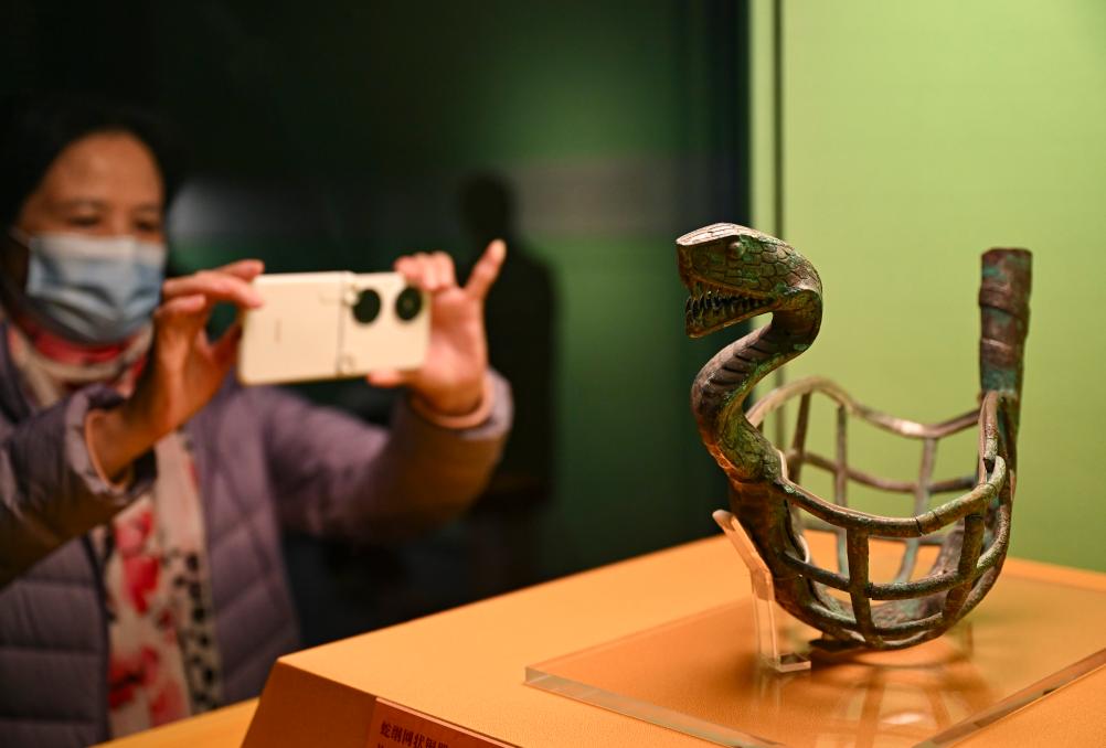 1月14日，觀眾在上海博物館蛇年迎春展拍攝展品蛇綱網(wǎng)狀銅器。新華社發(fā)（陳浩明攝）