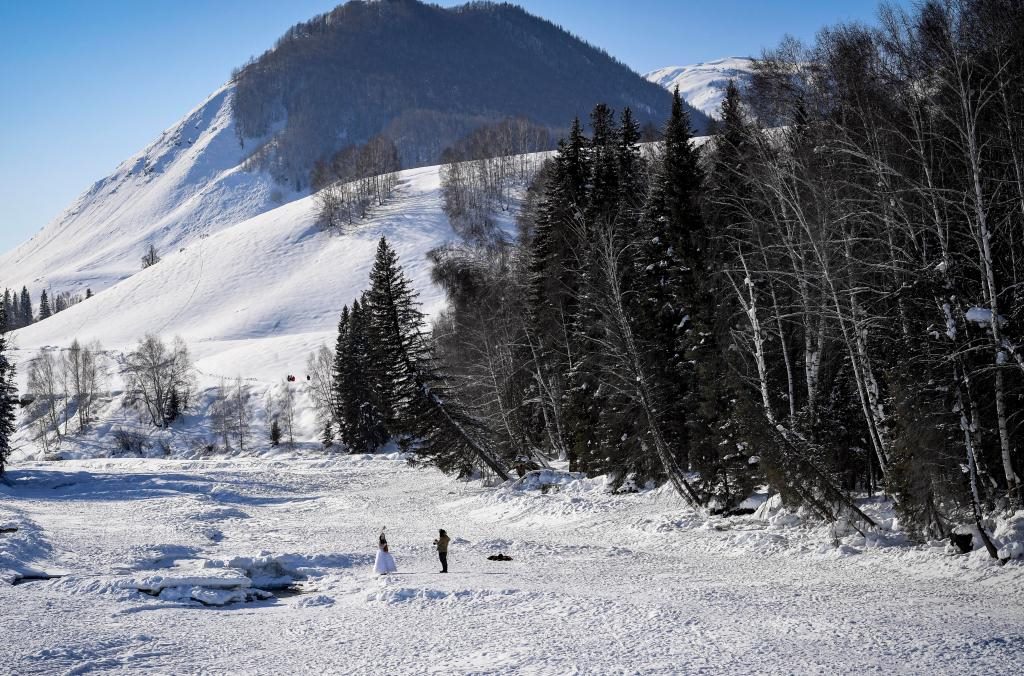 2024年2月5日，兩名游客在新疆阿勒泰地區(qū)布爾津縣禾木村拍照。新華社記者 馬鍇 攝