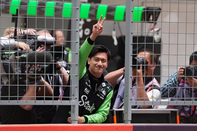 2024年4月19日，索伯車隊(duì)中國(guó)車手周冠宇（中）在練習(xí)賽前向觀眾致意。當(dāng)日，F(xiàn)1中國(guó)大獎(jiǎng)賽在上海開賽。中國(guó)車手周冠宇主場(chǎng)首秀參賽。新華社記者 夏一方攝