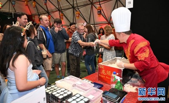 圖為游客在燈節(jié)現(xiàn)場(chǎng)購(gòu)買(mǎi)小吃。（圖片由奧克蘭中國(guó)文化中心提供）