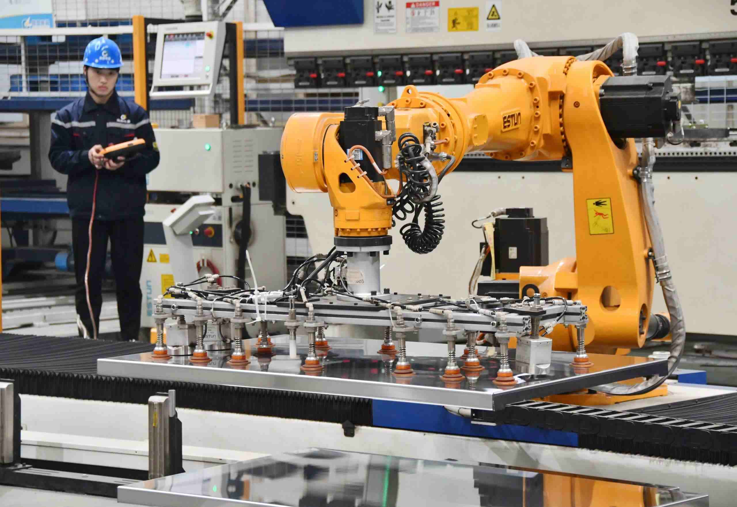 △2025年2月21日，河北邯鄲永年區(qū)工業(yè)園區(qū)的一家企業(yè)，工人正在操控工業(yè)機(jī)器人作業(yè)。