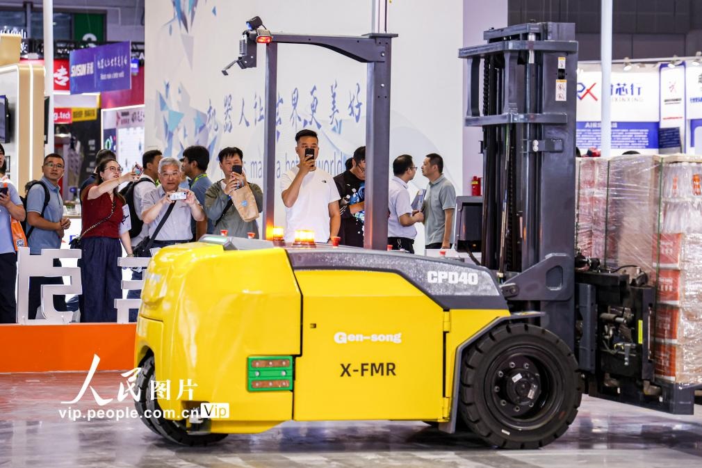 第24屆中國工博會(huì)現(xiàn)場，觀眾觀看叉取機(jī)器人作業(yè)演示。王初攝（人民圖片網(wǎng)）