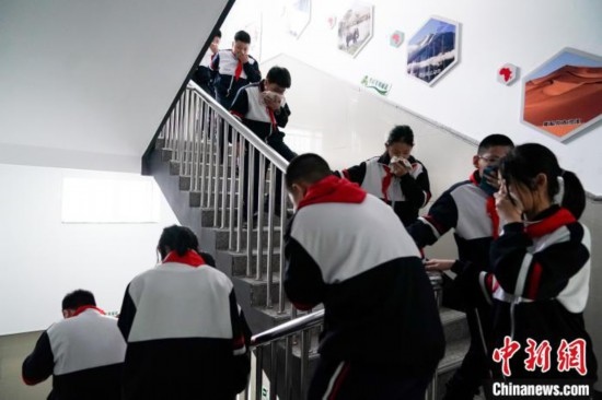  圖為學(xué)生們進(jìn)行應(yīng)急疏散演練。中新社記者 趙宇航 攝