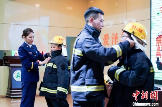 圖為學(xué)生們現(xiàn)場穿戴消防頭盔和戰(zhàn)斗服。中新社記者 趙宇航 攝