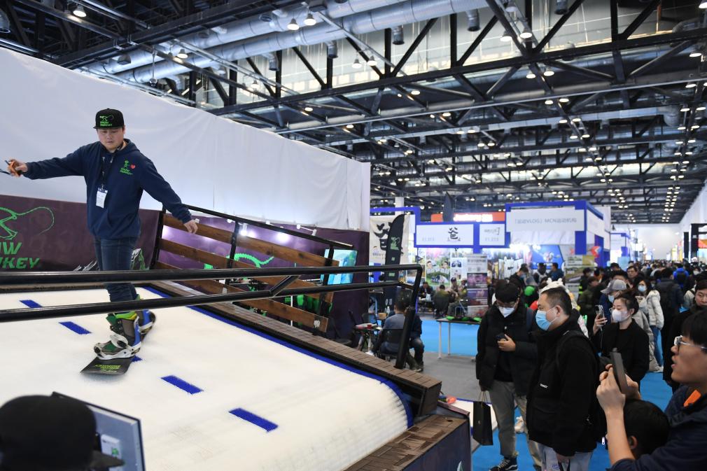 2023年2月11日，參觀者在展會上了解一款模擬滑雪設(shè)備。當(dāng)日，2023亞洲運動用品與時尚展在國家會議中心拉開帷幕。新華社記者 張晨霖 攝