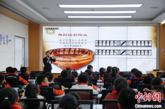 圖為學(xué)生在“國寶音樂會”社教課中了解舞蹈紋彩陶盆。中新社記者 馬銘言 攝