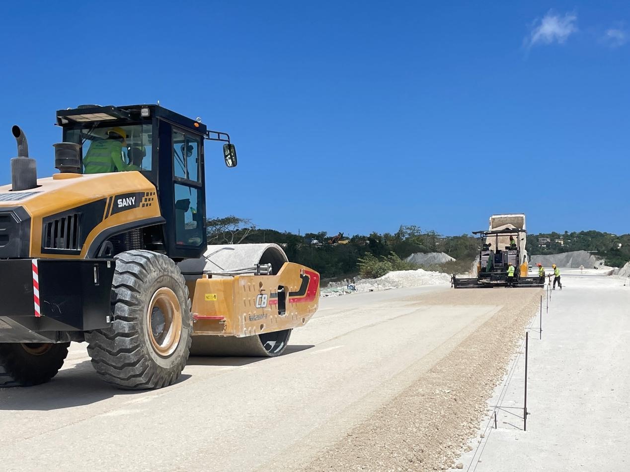 圖為中企承建的牙買加蒙特哥貝繞城路項(xiàng)目基層試驗(yàn)段正在進(jìn)行攤鋪和碾壓施工，相關(guān)施工工作已于日前順利完成。中國港灣美洲區(qū)域公司供圖