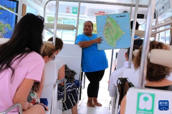 3月15日，一名導(dǎo)游在游艇上為游客介紹塞舌爾拉迪格島。新華社記者 董江輝 攝