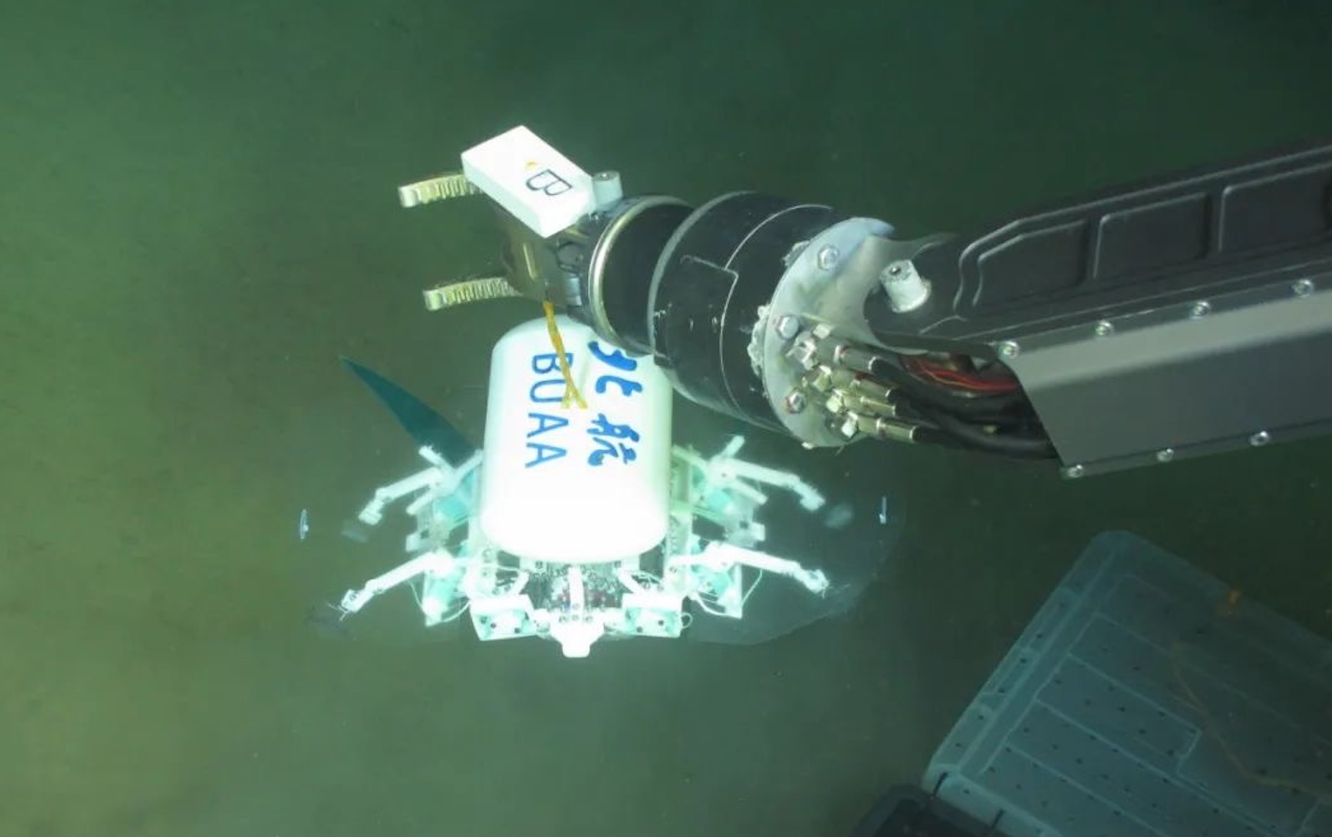 科研人員利用機(jī)械臂將北航深海小型機(jī)器人投于馬里亞納海溝。校方供圖