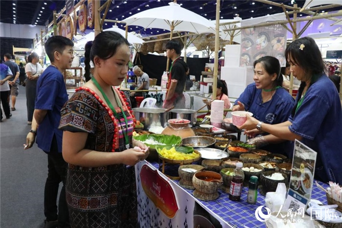 游客在攤位前購買特色美食。朱瀟逸攝