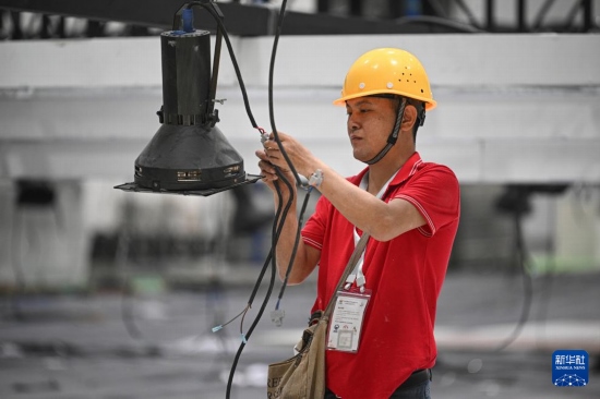 4月4日，工作人員在海南國(guó)際會(huì)展中心內(nèi)布設(shè)燈光。