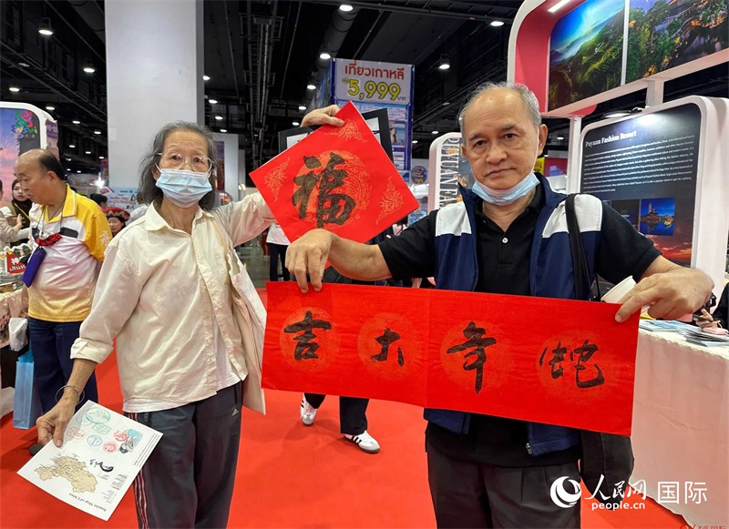 2025蛇年春節(jié)，泰國市民展示他們領(lǐng)到的華人手寫春聯(lián)。人民網(wǎng)記者 簡承淵攝