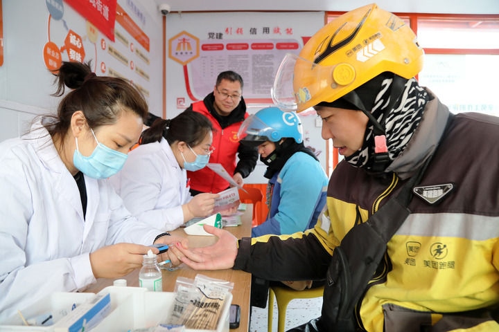 2025年3月5日，志愿者在山東省棗莊市市中區(qū)一工會驛站為外賣員免費(fèi)測量血糖。新華社發(fā)（王海楠攝）