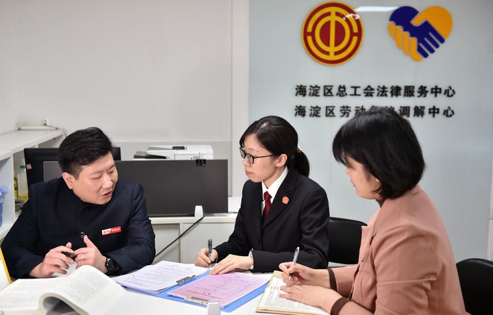 2025年3月6日，在北京市海淀區(qū)總工會勞動爭議調(diào)解中心，海淀區(qū)人民法院法官王琰（中）與該中心工作人員就糾紛化解情況進(jìn)行溝通。新華社記者 趙婷婷 攝