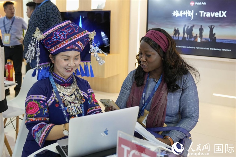 來(lái)自廣西的旅游業(yè)者同客戶(hù)交流。人民網(wǎng)塔里克·易卜拉欣攝