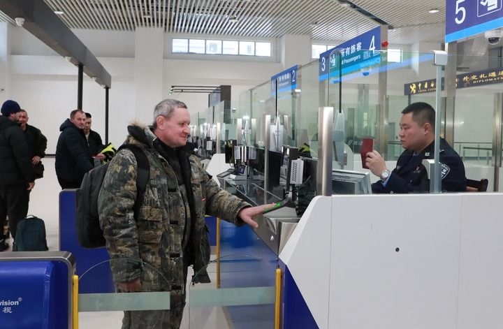 2024年12月10日，在黑河公路口岸旅檢大廳，黑河出入境邊防檢查站民警為首班次客車入境旅客辦理邊檢通關(guān)手續(xù)。當(dāng)日，中國(guó)黑河公路口岸—俄羅斯卡尼庫(kù)爾干公路口岸旅客運(yùn)輸正式開通。新華社發(fā)（劉松攝）