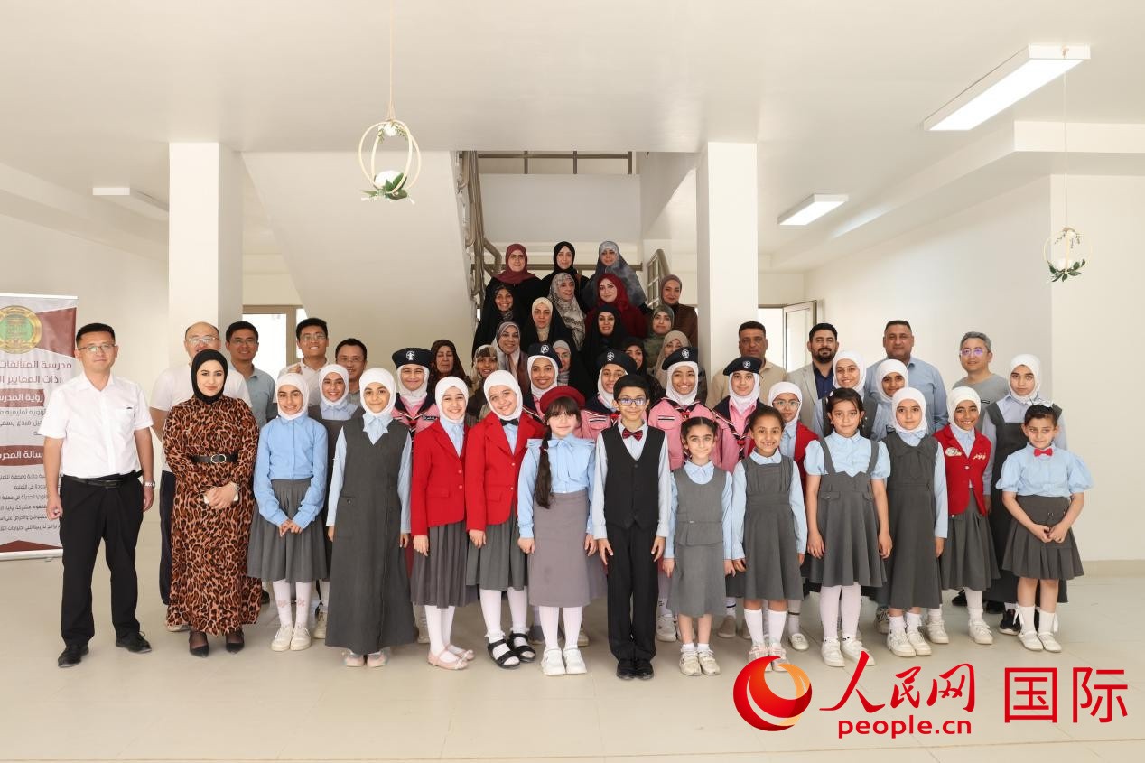 中國電建員工與阿爾穆塔?阿里卡特國際學(xué)校的師生及政府官員等合影。人民網(wǎng)記者 薛丹攝