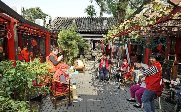 2024年10月12日，鐘樓灣胡同的老年人在社區(qū)內(nèi)的四合院養(yǎng)老驛站休閑。2017年起，北京市先后開展了兩輪背街小巷環(huán)境整治提升行動，完整保留了中軸線生活建筑群的歷史信息，并根據(jù)居民的生活和居住方式進(jìn)行適配化的更新和改造，極大地改善了生活環(huán)境。2023年鐘樓灣胡同被評為“北京最美街巷”。