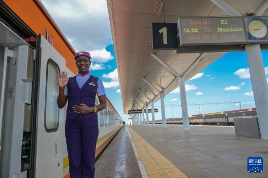 5月31日，在蒙內(nèi)鐵路內(nèi)羅畢站，一名乘務員在即將開往蒙巴薩的E2次列車旁等候乘客。新華社記者 楊光 攝