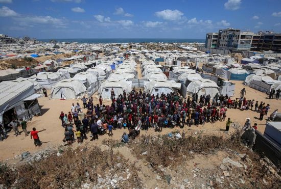 5月28日，人們在加沙城西部的沙提難民營等待領(lǐng)取救助食物。新華社發(fā)（里澤克·阿卜杜勒賈瓦德攝）