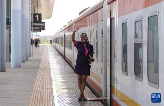 5月31日，在蒙內(nèi)鐵路內(nèi)羅畢站，一名乘務員在即將開往蒙巴薩的E2次列車旁等候乘客。新華社記者 李亞輝 攝